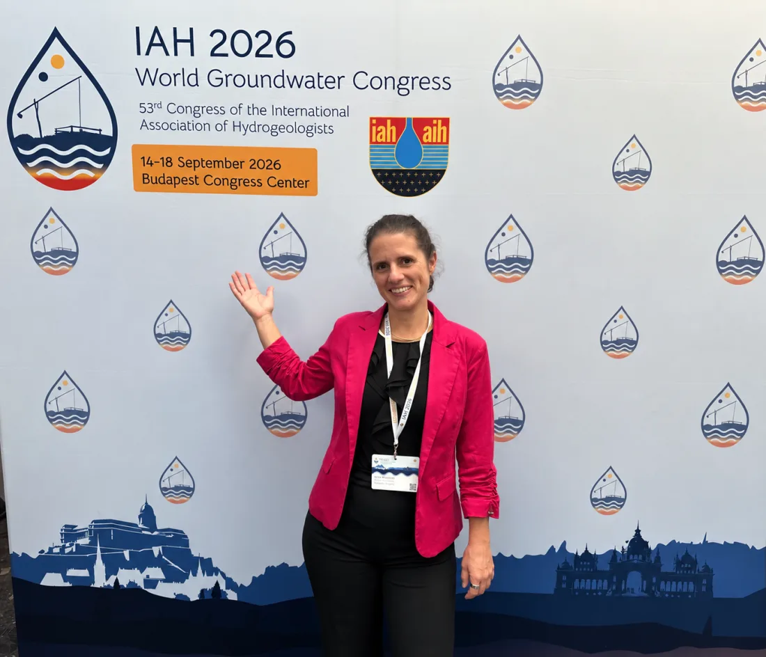 Krasznói Anna az IAH 2026 Világkongresszus fotófala előtt, a budapesti kongresszusi központban